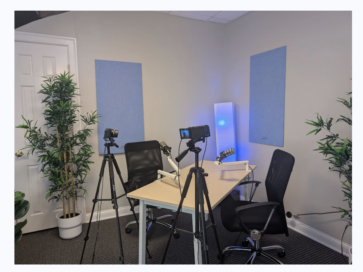 Área de conversación en FreePodcast Center con sillones y micrófonos profesionales